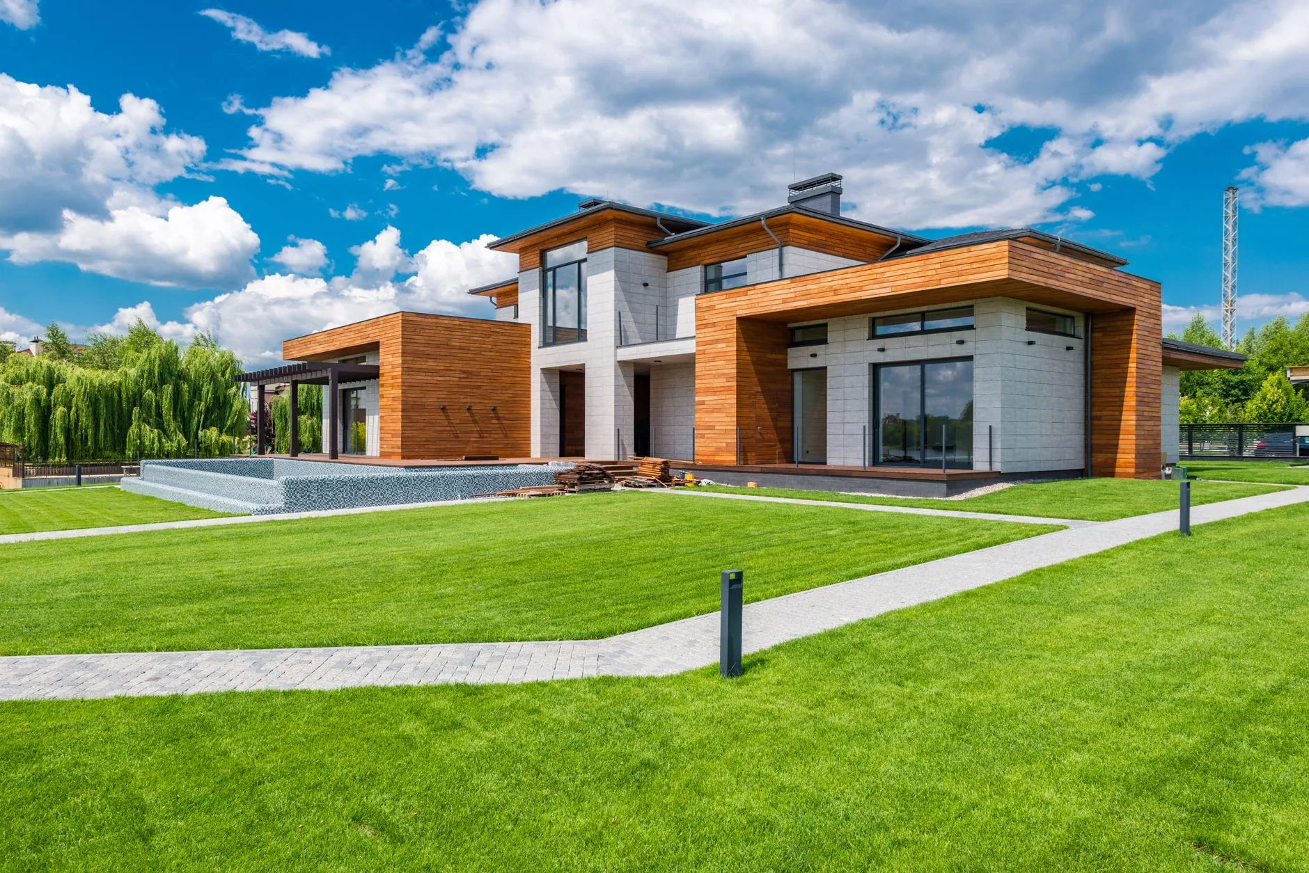 Contemporary luxury home with warm wood architecture and an expansive lawn